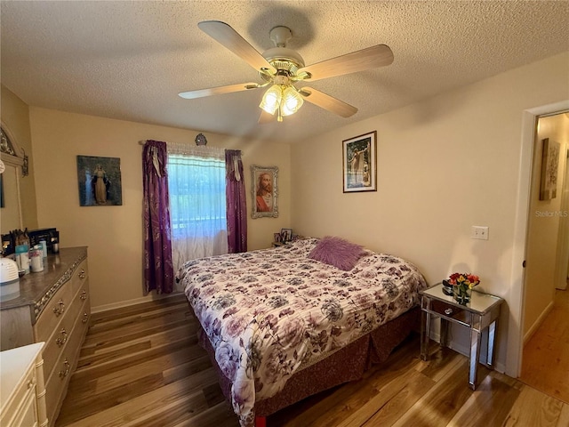 bedroom with a textured ceiling, ceiling fan, and wood finished floors