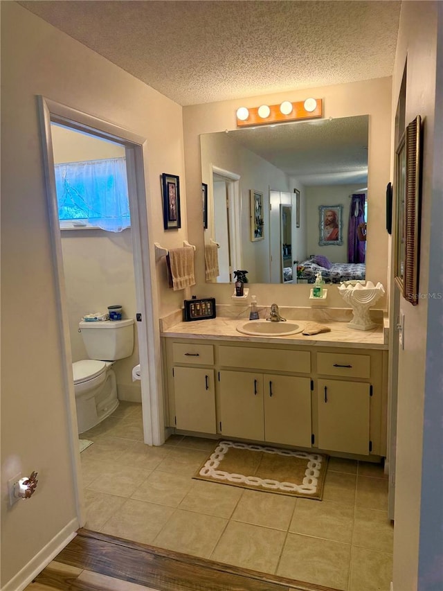 bathroom featuring a textured ceiling, tile patterned flooring, vanity, and toilet