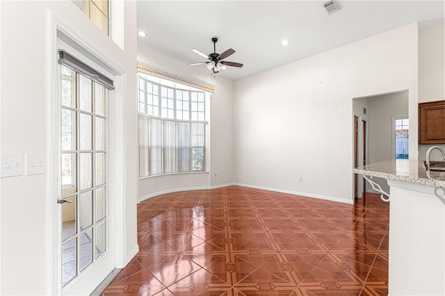 unfurnished dining area featuring ceiling fan and dark parquet floors