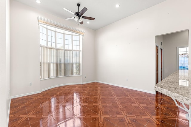 spare room with ceiling fan and dark parquet floors