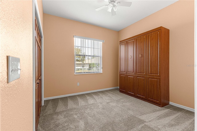 unfurnished bedroom featuring light colored carpet and ceiling fan