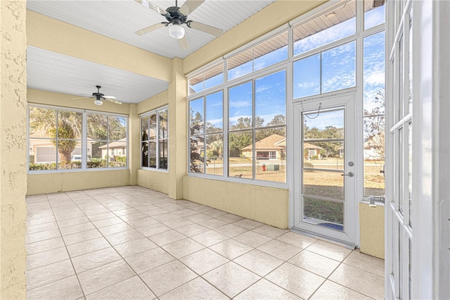 unfurnished sunroom with ceiling fan