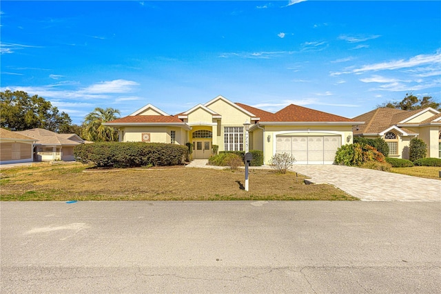 ranch-style home with a garage and a front lawn