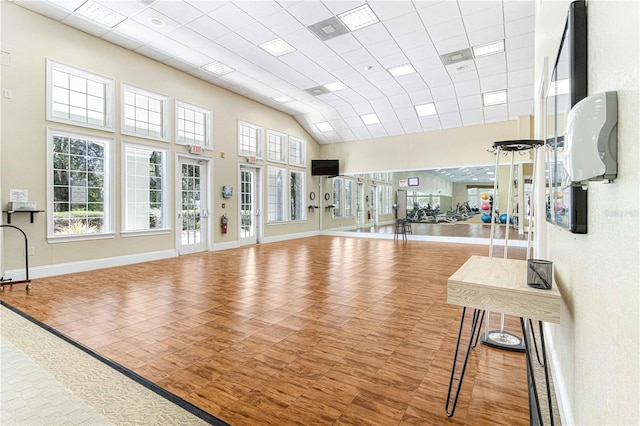 workout area featuring a healthy amount of sunlight, a drop ceiling, and a high ceiling