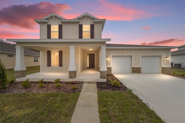 view of front of home with a porch, a garage, and a lawn