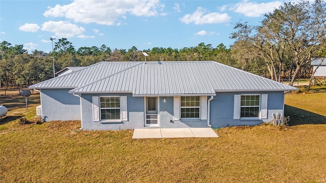 back of property with a patio area and a lawn