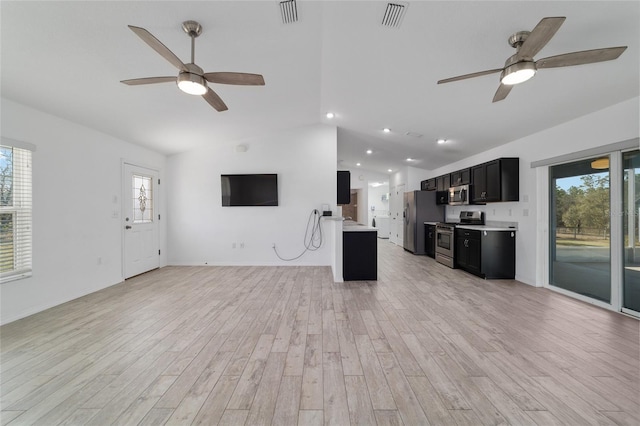 unfurnished living room with lofted ceiling, ceiling fan, light hardwood / wood-style floors, and a healthy amount of sunlight