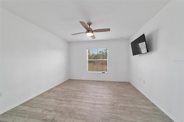 spare room featuring a textured ceiling, ceiling fan, and light hardwood / wood-style flooring