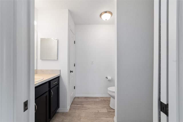 bathroom with vanity, wood-type flooring, and toilet