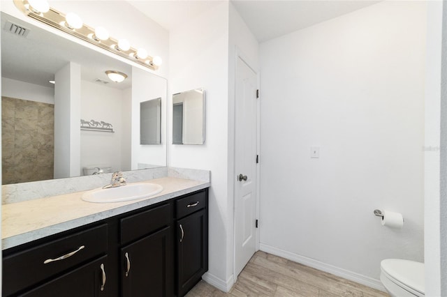 bathroom with hardwood / wood-style flooring, vanity, and toilet