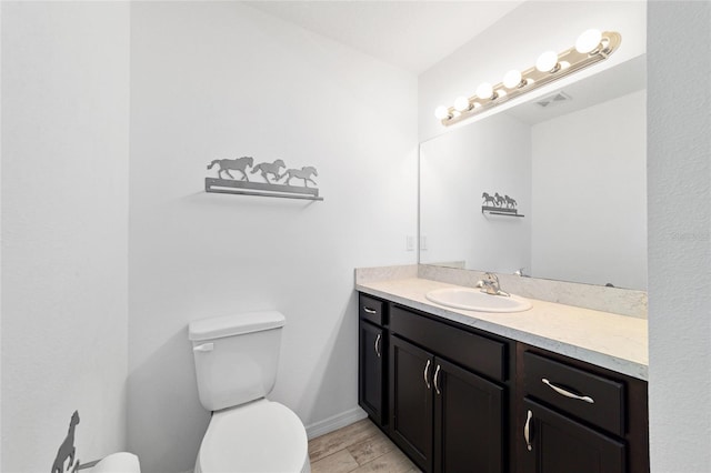 bathroom with vanity, wood-type flooring, and toilet