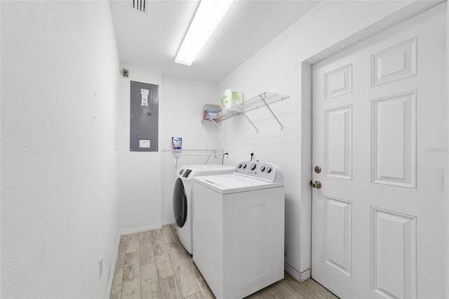 washroom featuring light hardwood / wood-style floors, electric panel, and independent washer and dryer