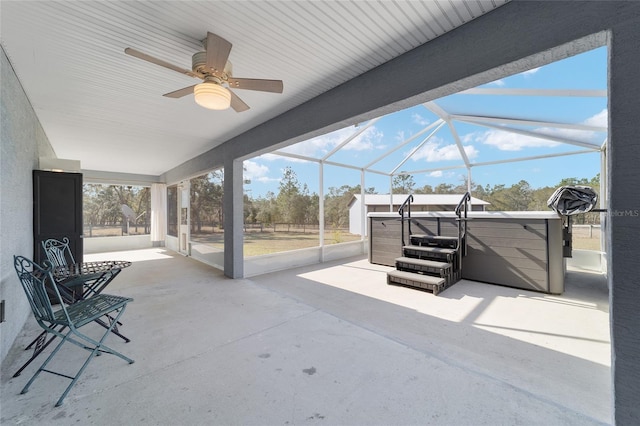 view of patio featuring a hot tub and a lanai