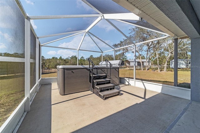 view of patio / terrace featuring a lanai and a hot tub