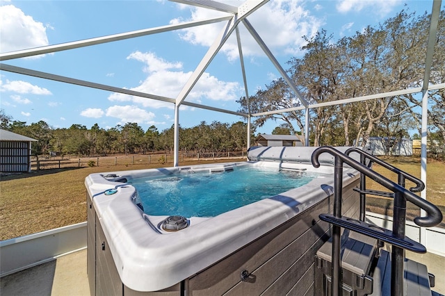 view of pool featuring a hot tub, a lanai, and a lawn