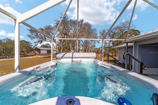 view of swimming pool featuring a yard and glass enclosure