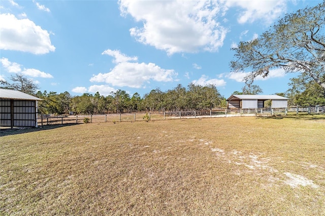 view of yard featuring an outdoor structure and a rural view