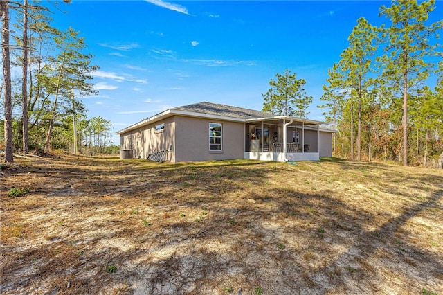 back of house with a yard and a sunroom