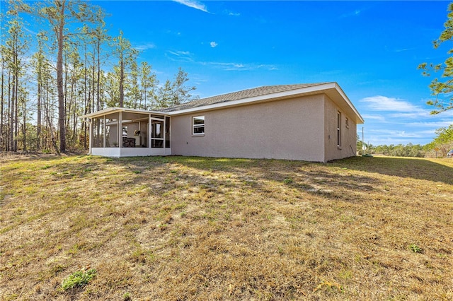 rear view of house with a sunroom and a lawn