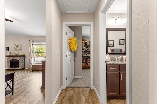 hallway with sink and light hardwood / wood-style floors