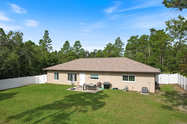 rear view of property featuring a lawn, a patio area, and central air condition unit