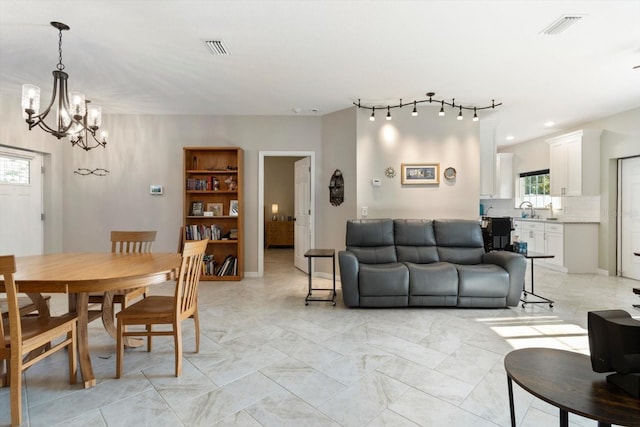 dining space with sink and a notable chandelier