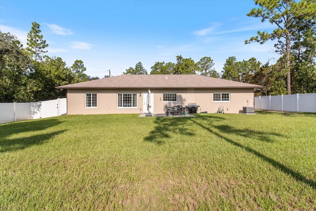 back of property featuring a yard and central AC