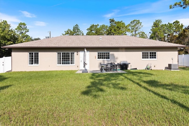 rear view of property featuring central AC unit and a yard