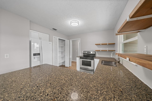 kitchen with white cabinetry, sink, white refrigerator with ice dispenser, a textured ceiling, and electric stove