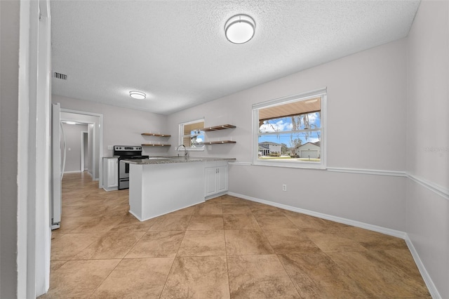 kitchen with sink, white cabinetry, a textured ceiling, kitchen peninsula, and electric stove