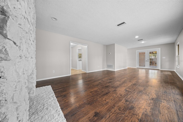 unfurnished living room with french doors, dark wood-type flooring, and a textured ceiling