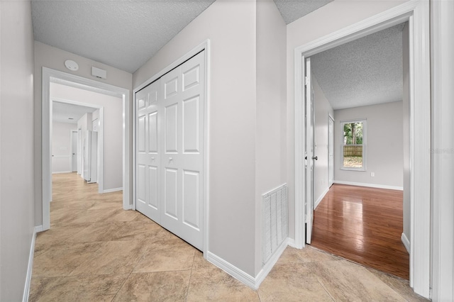 hallway with a textured ceiling