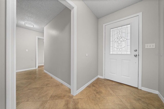 tiled entrance foyer featuring a textured ceiling