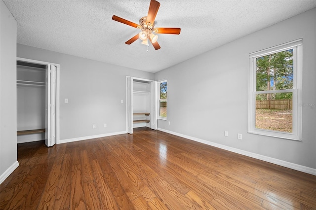 unfurnished bedroom with ceiling fan, wood-type flooring, and a textured ceiling