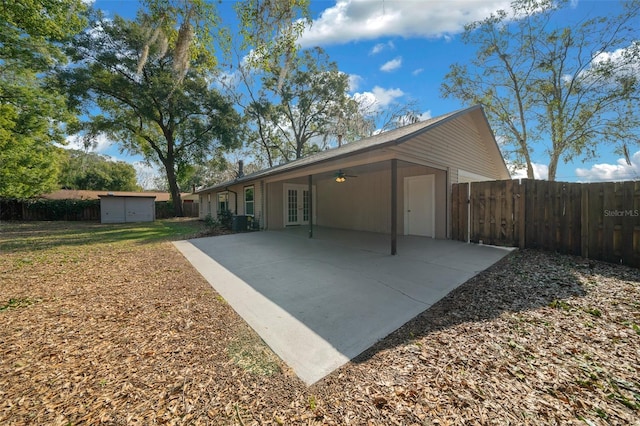 rear view of house with central air condition unit, a patio area, ceiling fan, and a storage unit