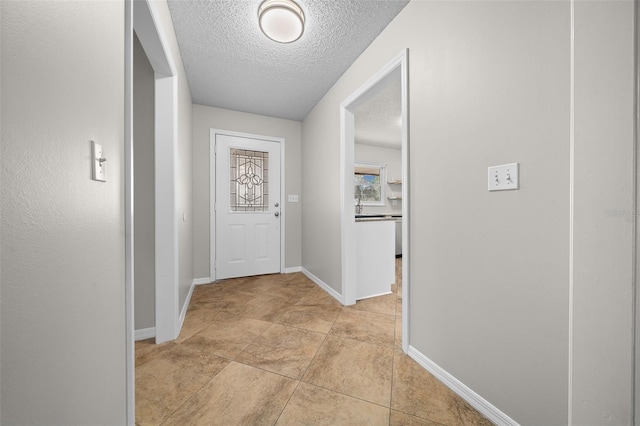 doorway to outside featuring a textured ceiling