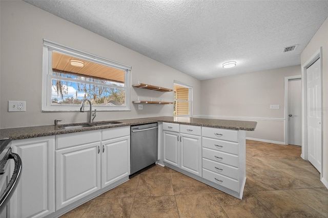 kitchen featuring sink, a textured ceiling, stainless steel dishwasher, kitchen peninsula, and white cabinets