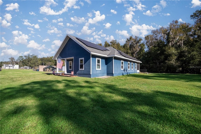 view of home's exterior featuring a lawn and solar panels