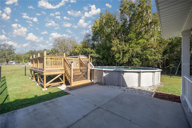 view of swimming pool with a wooden deck, a yard, and a patio