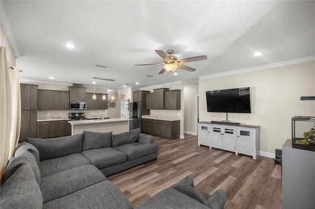 living room featuring dark wood-type flooring, ceiling fan, and ornamental molding