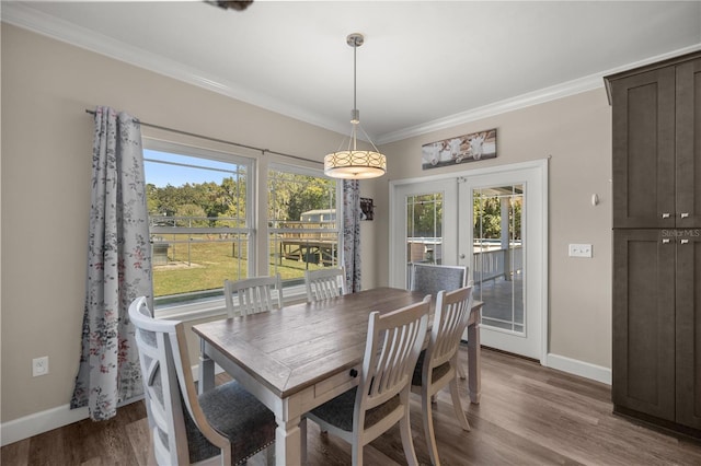 dining room with crown molding, a healthy amount of sunlight, hardwood / wood-style floors, and french doors