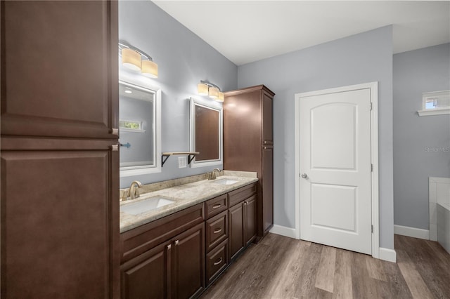 bathroom with hardwood / wood-style flooring, vanity, and a bath