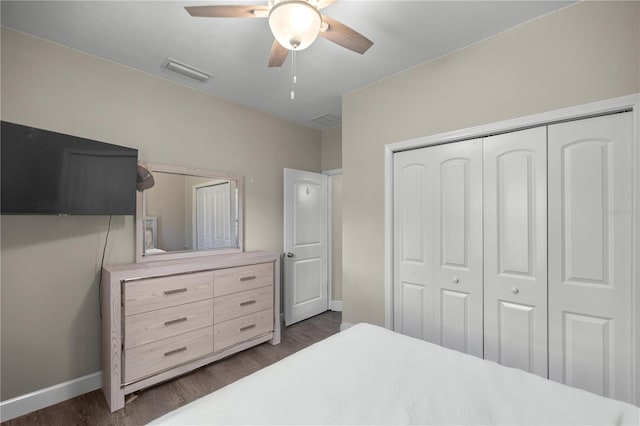 bedroom with ceiling fan, dark hardwood / wood-style floors, and a closet