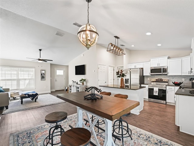 dining room with ceiling fan, high vaulted ceiling, sink, and dark hardwood / wood-style flooring