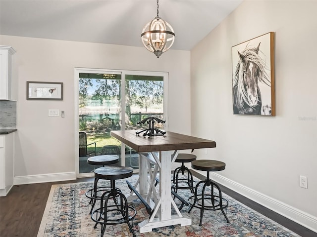 dining area featuring an inviting chandelier, dark hardwood / wood-style floors, and vaulted ceiling