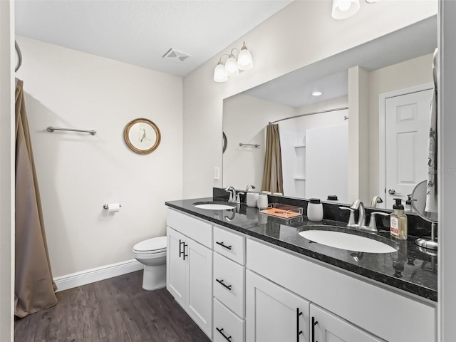 bathroom featuring vanity, hardwood / wood-style floors, curtained shower, and toilet