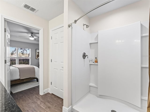 bathroom with a shower, hardwood / wood-style floors, and ceiling fan