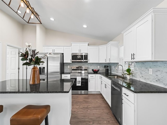 14605 SW 20th Pl, Ocala, FL 34481 - kitchen featuring vaulted ceiling, a sink, white cabinetry, appliances with stainless steel finishes, and dark wood-style floors
