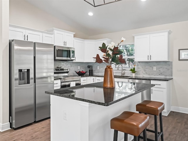 14605 SW 20th Pl, Ocala, FL 34481 - kitchen featuring backsplash, a sink, wood finished floors, stainless steel appliances, and white cabinets