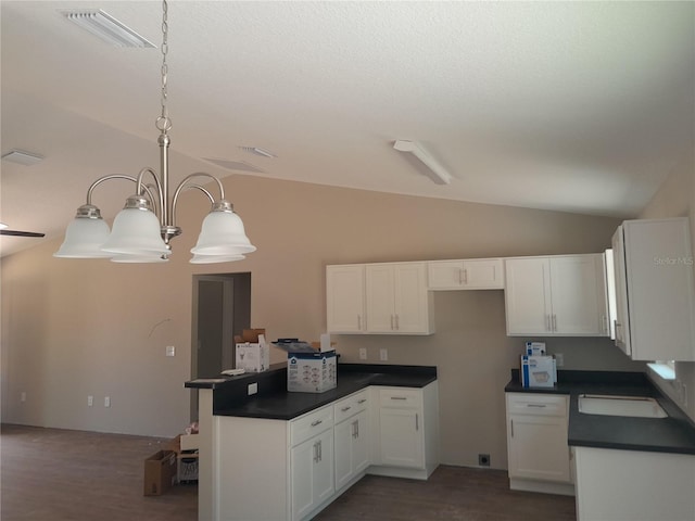 46 Malauka Dr, Ocklawaha, FL 32179 - kitchen featuring dark countertops, a peninsula, white cabinets, lofted ceiling, and visible vents